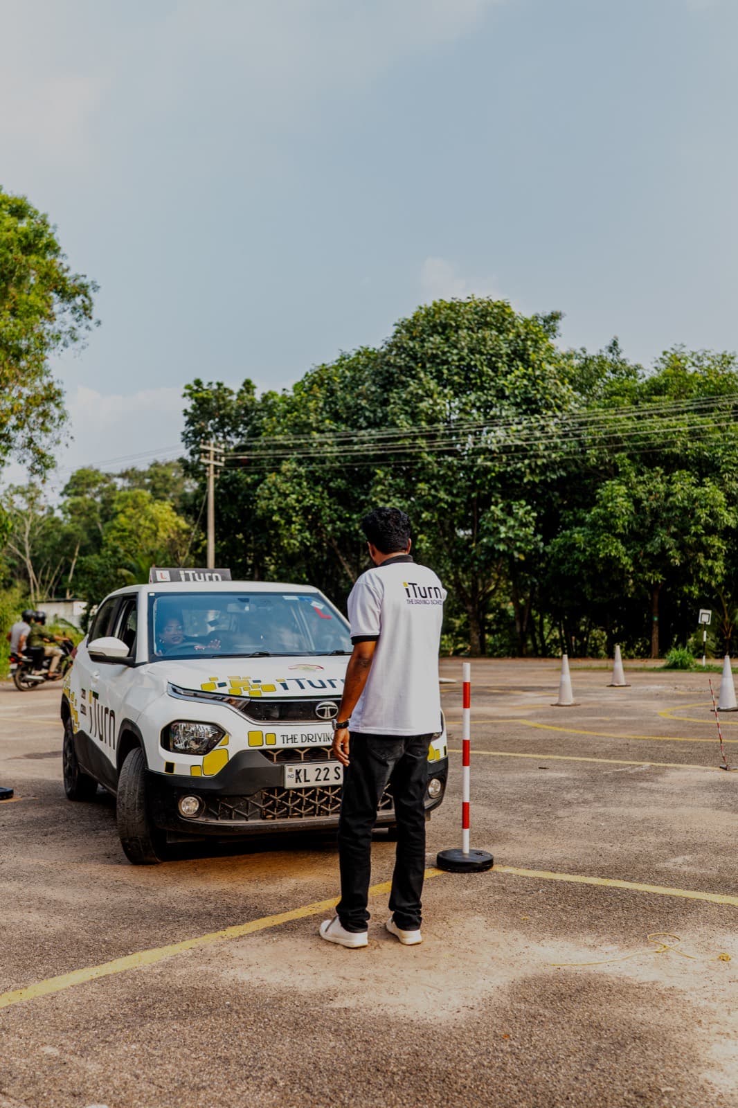 Careful, patient instruction beside an iTurn training car