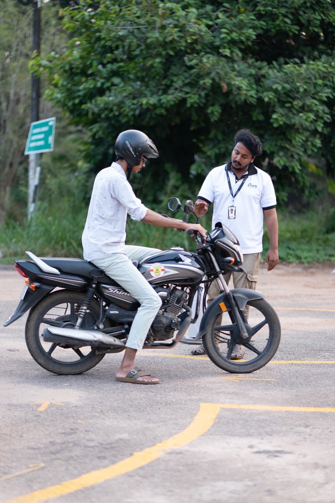 Instructor coaching a learner on a motorcycle